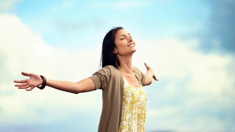 Femme qui pratique la respiration lente en pleine nature pour se détendre et retrouver de l’énergie