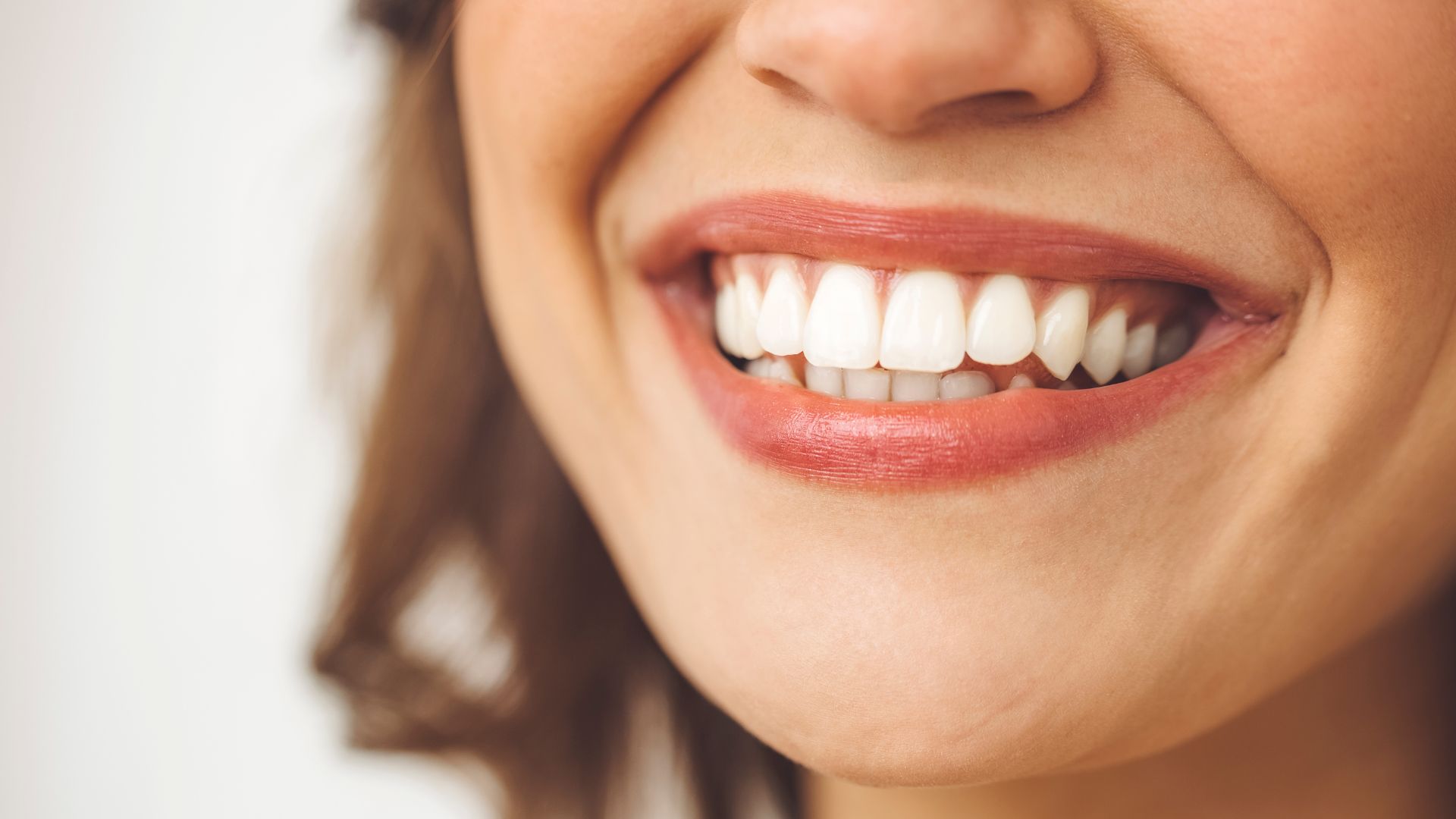 Femme souriant à pleines dents, illustrant les effets du sourire sur la détente
