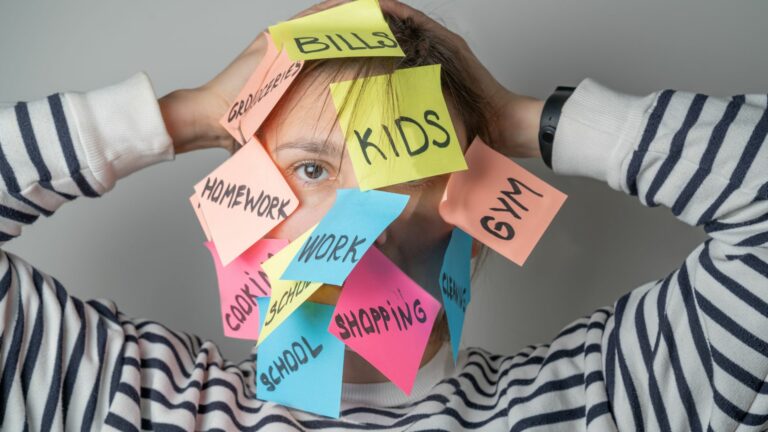femme débordée avec des post-it sur le visage symbolisant la charge mentale
