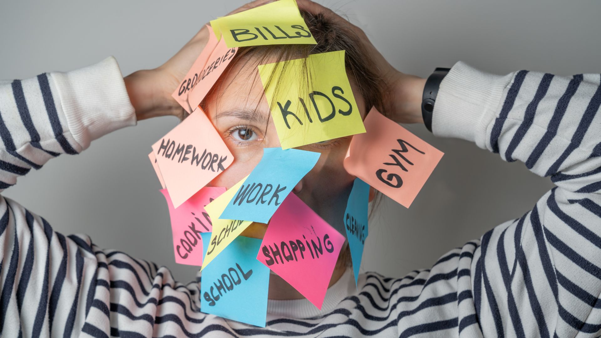 femme débordée avec des post-it sur le visage symbolisant la charge mentale