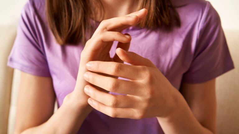 Femme pratiquant l’EFT en tapotant le point Karaté pour apaiser ses émotions.